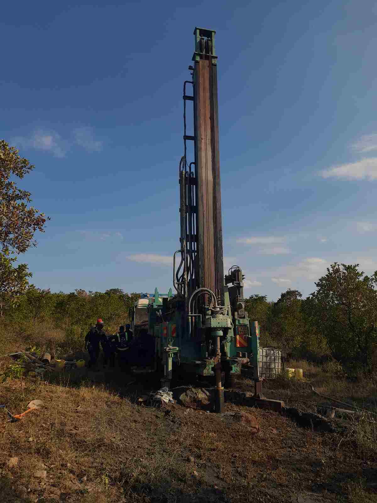 Borehole drilling rig at field site with crew